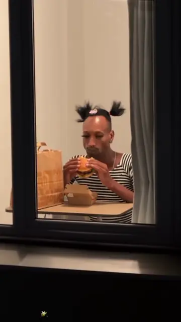 Space buns and a striped top at the lit window