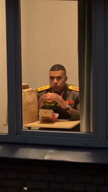 A dress uniform with medals, still eating the burger