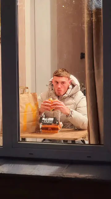 A white puffer jacket in the lit window, caught mid-bite